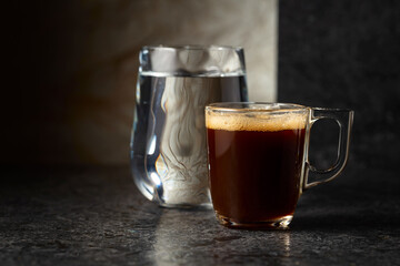 Wall Mural - Espresso and glass of cold water on a black background.