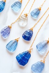 Canvas Print - Artistic flat-lay of blue gemstone necklaces featuring elegant gold accents arranged on a light marble surface highlighting their sparkle and refinement