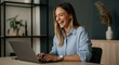 © Artyom - Laughing woman working on laptop at home office