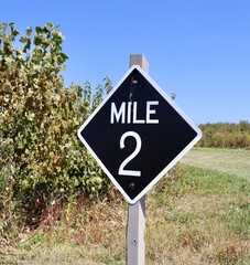 Wall Mural - A close view of the black and white mile two sign.