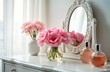 © Pete - Pink flowers in white dressing table. Elegant flowers, perfumes in bright interior. Close-up of white boudoir table with copy space. Bunch of fresh pink flowers in vase on table, next to mirror,