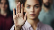 © Arialvetica - Professional woman holding her palm outward in a Stop gesture emphasizing inclusivity and boundary-setting in the workplace.