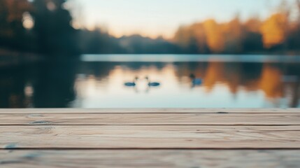 Poster - Empty wooden table by lake with ducks swimming, soft natural light, serene outdoor vibe