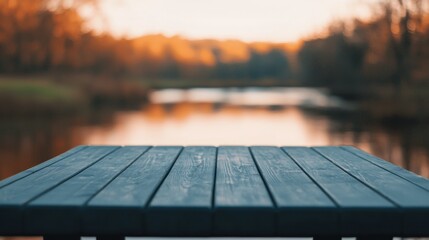 Poster - Empty wooden table overlooking tranquil river at sunset