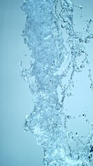 Fototapete - Super Slow Motion of Flying Water Splashes, Isolated on Blue Background. Filmed on High Speed Cinema Camera, 1000fps. Vertical Aspect Ratio.