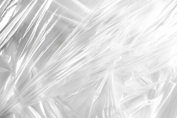 Poster - Smooth, glistening surface of crumpled plastic wrap forms an abstract pattern of intersecting lines and folds, capturing the interplay of light and shadow