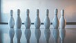 © Suphawan - Close-up of bowling pins standing perfectly aligned after being set up, ready for the next round