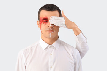 Wall Mural - Young woman covering eye of man in paint on white background, closeup