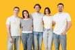 © Pixel-Shot - Group of young people in jeans hugging on yellow background