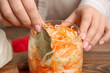 © Pixel-Shot - Woman putting bay leaf into jar with sauerkraut in kitchen. Closeup