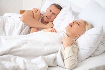 Wall Mural - Mature man cannot sleep because of his wife's snoring in bedroom