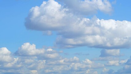 Wall Mural - Beautiful fluffy clouds drifting across a bright blue sky during a sunny afternoon in a peaceful outdoor setting. Calm and romantic background with clouds on the weather theme.