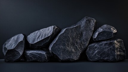 Aufkleber - Geometric black stones with textured surfaces arranged in an abstract composition, lit with artistic lighting effects to highlight their unique form