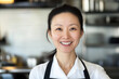 © Aleksandra - Smiling Asian Female Chef in Kitchen Wearing Apron