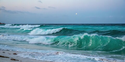 Ocean waves at night with a turquoise green hue rolling towards the shore under a light blue sky, water, oceanic