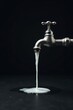 © napak - A metallic faucet pours a continuous stream of creamy white liquid onto a dark surface
