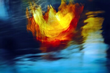 Poster - Abstract vibrant flame emerging from water surface with blurred motion in colorful artistic visual representation of passion and energy in nature