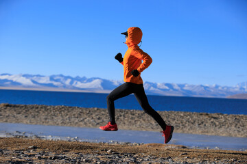 Wall Mural - Woman runner training at winter lakeside