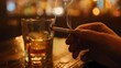 © Andre - Eine Hand mit Zigarette vor einem Glas mit Alkohol.