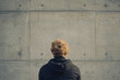© Image Tree - Back view of a person staring at a blank concrete wall