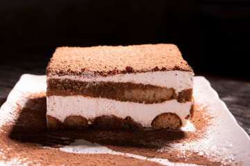 Wall Mural - Tiramisu cake dessert served with coffee, biscuit and cocoa on dark background.spoon. Dessert. Food Concept