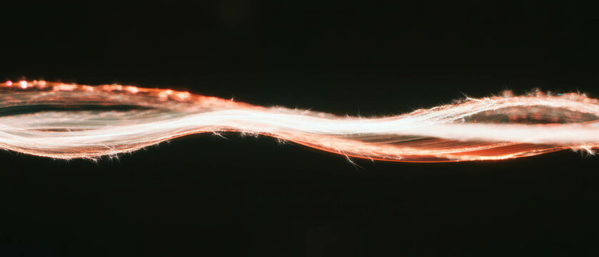 Bright light trails form dynamic spark patterns against a black backdrop with empty middle space