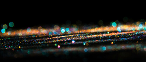 Poster - Vibrant glitter texture with iridescent particles on a black background