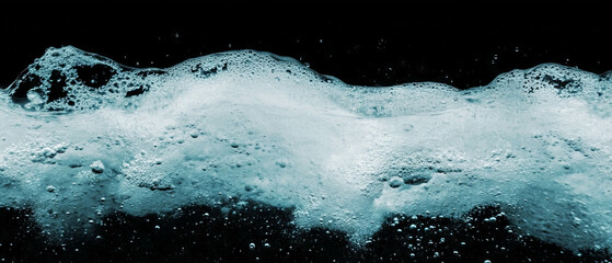Poster - Dynamic air bubbles rising through water on a dark background creating a unique texture