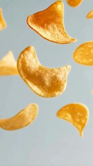 Poster - Several golden brown potato chips are levitating against a light blue backdrop, creating a visually appealing scene that suggests snacking and enjoyment