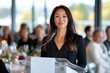 © Milos - A confident woman stands at a podium addressing the audience, symbolizing leadership, empowerment, and the importance of communication in professional settings.