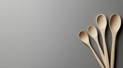 Wall Mural - A wooden spoon set is displayed on a grey background