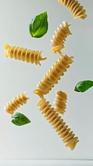 Aufkleber - Several pieces of fusilli pasta and basil leaves are levitating against a minimalist white background, creating a visually appealing scene related to italian cuisine