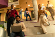 © DusanJelicic - Focused freelancer working remotely while students rush upstairs in busy university hall