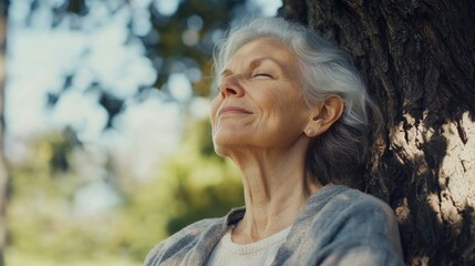 Poster - Serene elderly woman practicing mindfulness meditation outdoors beside a tree in a tranquil park setting.