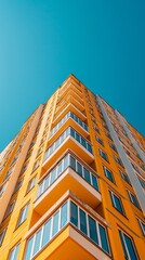 Aufkleber - A contemporary yellow building with bold white lines ascends into the azure sky. Its numerous balconies reflect sunlight, creating a warm and inviting atmosphere in the city