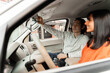 © Maria Vitkovska - Young man adjusting rearview mirror while driving with his girlfriend