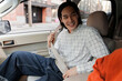 © Maria Vitkovska - Asian man fastening seat belt while sitting in car