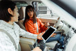© Maria Vitkovska - Driving instructor showing tablet to student inside car