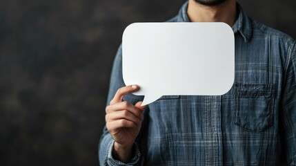 Poster - Adult man in blue plaid shirt holding a white blank speech bubble for text against a dark textured background, concept communication and ideas.