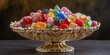 © The 2R Artificiality - Elegant semi-baroque style golden candy dish filled with an array of colorful assorted gummy candies on a dark wooden surface with empty copy space.