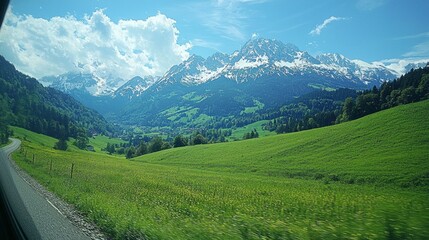 Aufkleber - In this serene landscape, vibrant green fields stretch towards majestic snow-capped mountains, where the sun shines brightly and fluffy clouds drift lazily across the azure sky, inviting tranquility