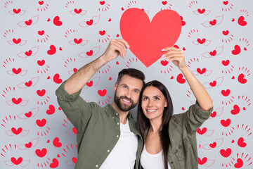 Poster - Portrait of attractive cheerful couple hugging holding heart card romance 14 February isolated over grey pastel color background