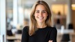 © Tondone - A confident young woman with a warm smile poses in a modern office environment. She exudes professionalism and positivity, making a great impression in any workplace setting.