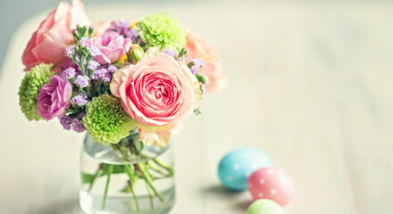 Wall Mural - Spring Floral Bouquet with Pastel Easter Eggs on Light Wooden Surface