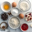 © Foodography Studio - Baking Ingredients: An overhead view of ingredients for a homemade dessert, featuring chocolate chips, eggs, flour, butter, sugar, vanilla extract and a dash of cinnamon.