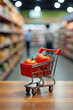 © Vladimir - Large tomatoes in miniature shopping cart in supermarket aisle