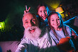© deagreez - Cheerful grandfather making memories with two lovely granddaughters on a relaxing evening at home