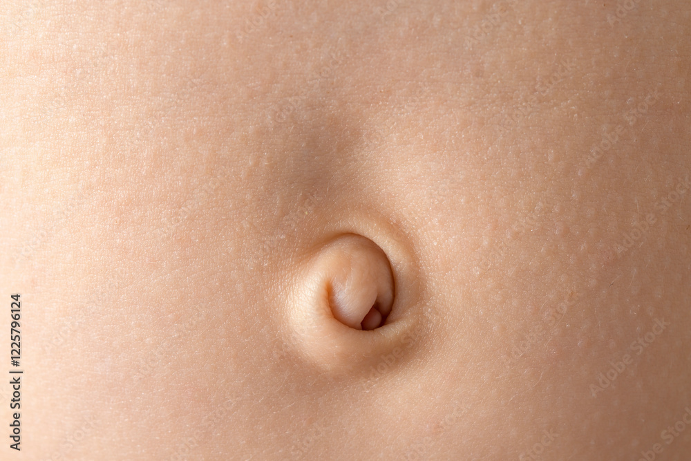 Close-up of a baby navel with delicate skin in soft lighting, highlighting the texture.