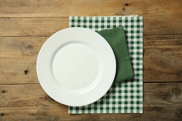 Wall Mural - Napkins and empty plate on wooden table, top view