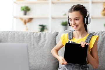 Poster - Distance Education. Smiling girl having video call with teacher, holding digital tablet with blank empty screen showing done task result using laptop. Child studying remotely